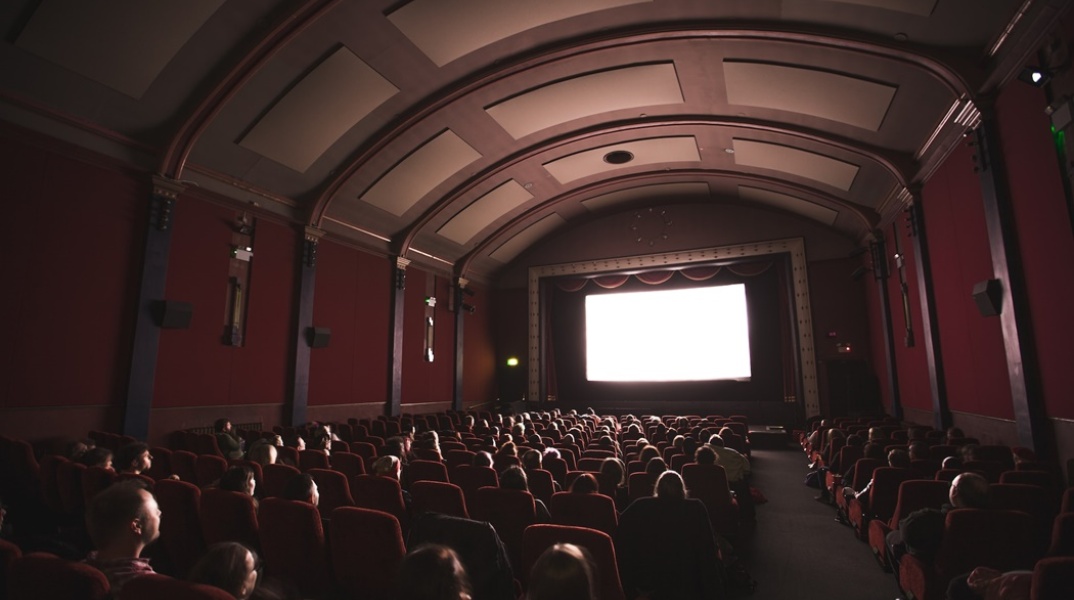 Πολίτες καθισμένοι στις θέσεις τους παρακολουθούν σινεμά