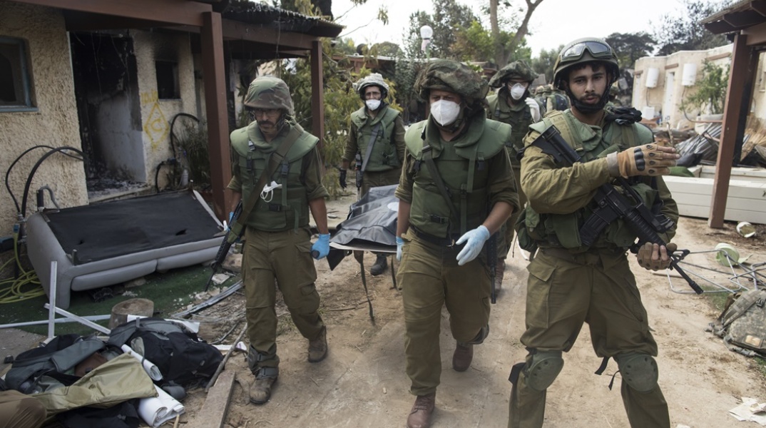 Ισραηλινοί στρατιώτες μεταφέρουν πτώμα από τη ρημαγμένη πόλη Κφαρ Αζα