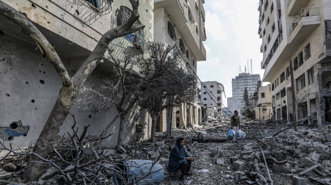 Γυναίκα κάθεται σε χαλάσματα σε πόλη του Ισραήλ