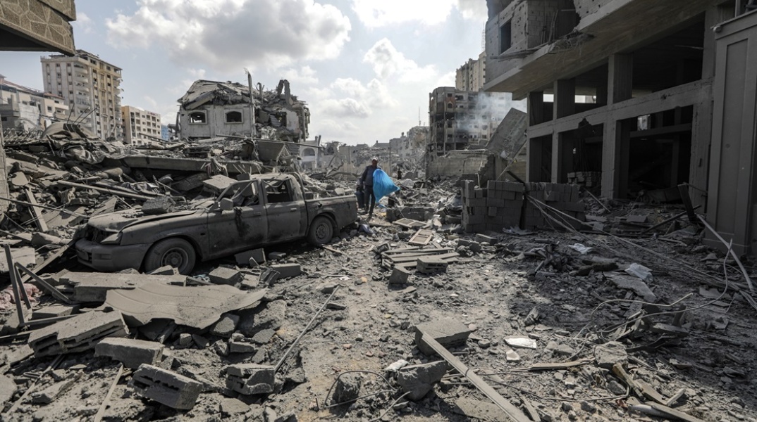 Άνδρας περπατά ανάμεσα στα χαλάσματα στη Γάζα