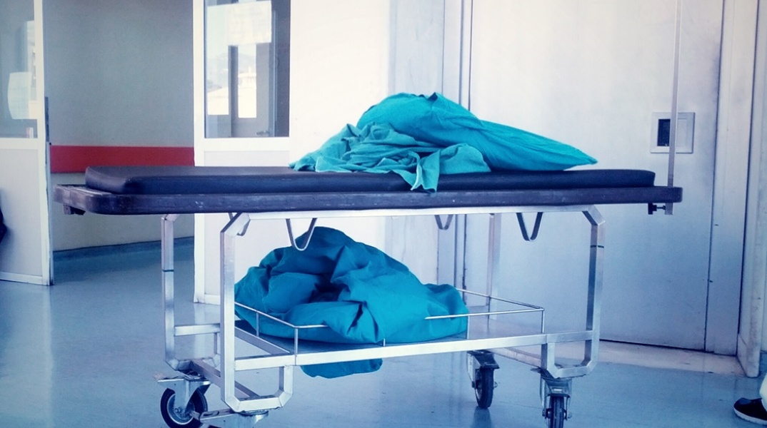 Φορείο στη μέση διαδρόμου και πάνω του διπλωμένα σεντόνια