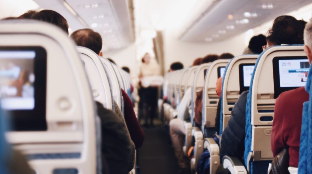 Επιβάτες σε αεροπλάνο κάθονται στις θέσεις τους