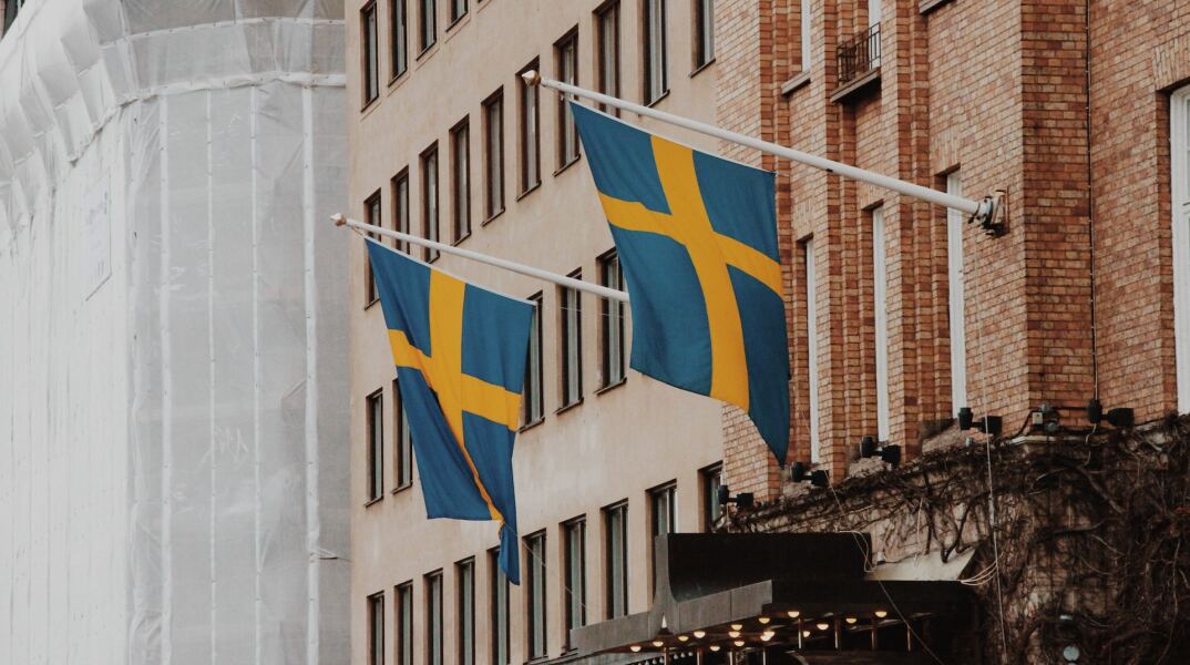 Σημαίες της Σουηδίας κρεμασμένες σε κτίριο στη χώρα