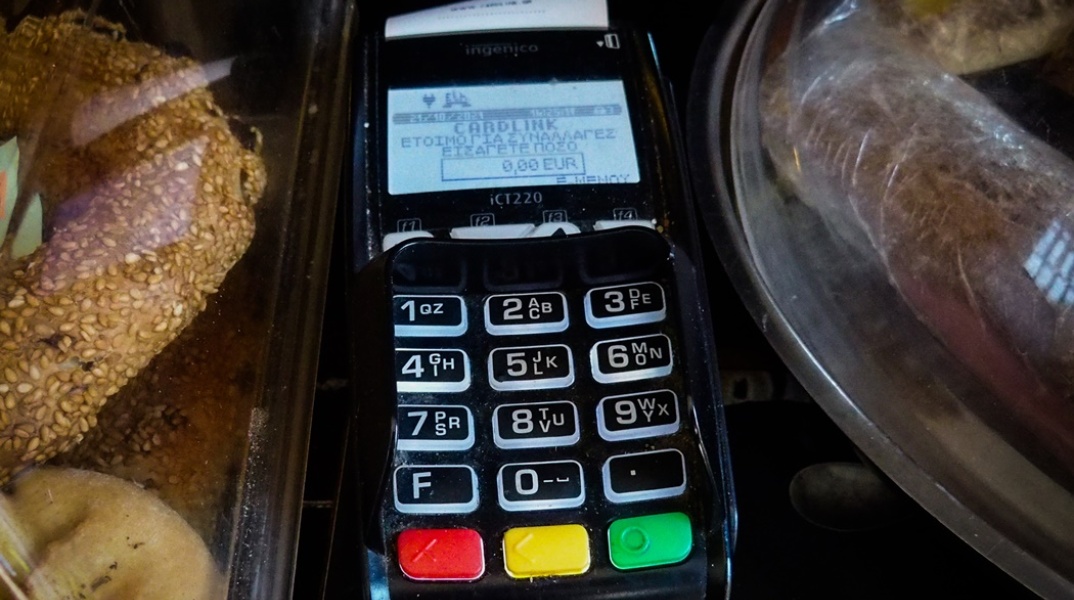 Μηχάνημα POS για τις τραπεζικές συναλλαγές δίπλα σε αρτοσκευάσματα