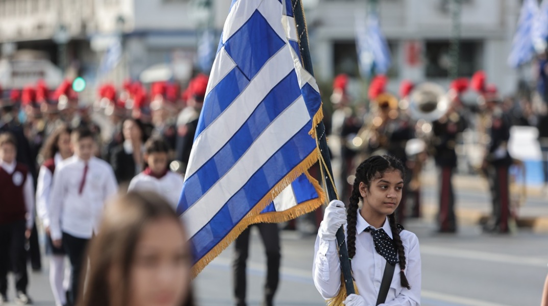 Στιγμιότυπο από την περσινή παρέλαση της 28ης Οκτωβρίου με μαθήτρια που κρατά την ελληνική σημαία