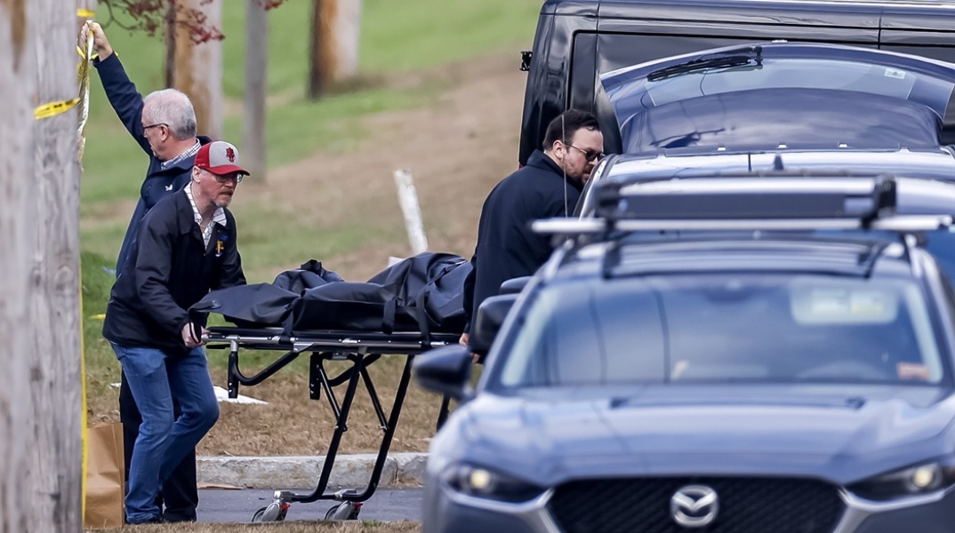 Οι αρχές μεταφέρουν πτώμα μέσα σε σάκο μετά το μακελειό με τους 18 νεκρούς στο Μέιν