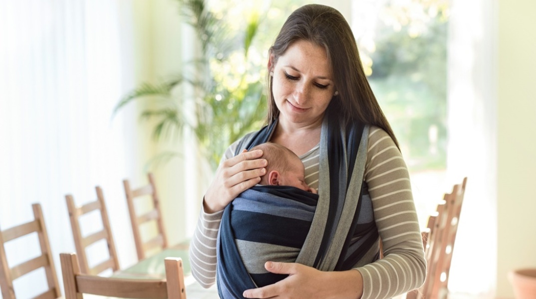 Μητέρα έχει σε μάρσιπο το μωράκι της