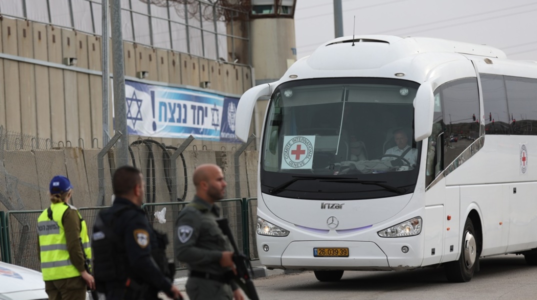 Δυνάμεις κοντά σε λεωφορείο του Ερυθρού Σταυρού που χρησιμοποιείται για τη μεταφορά ομήρων