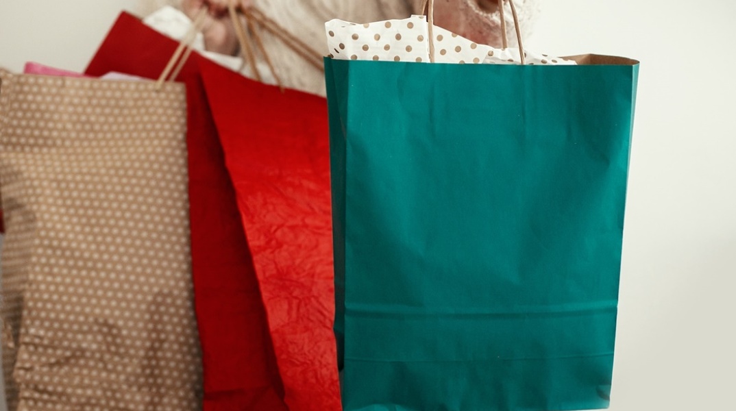 Άτομο κρατά σακούλες με ψώνια - Εικόνα που παραπέμπει και στις αγορές από τη Cyber Monday 2023