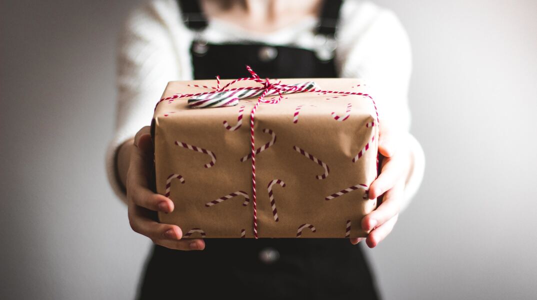 Γυναίκα κράτα κουτί τυλιγμένο με χριστουγεννιάτικο αμπαλάζ