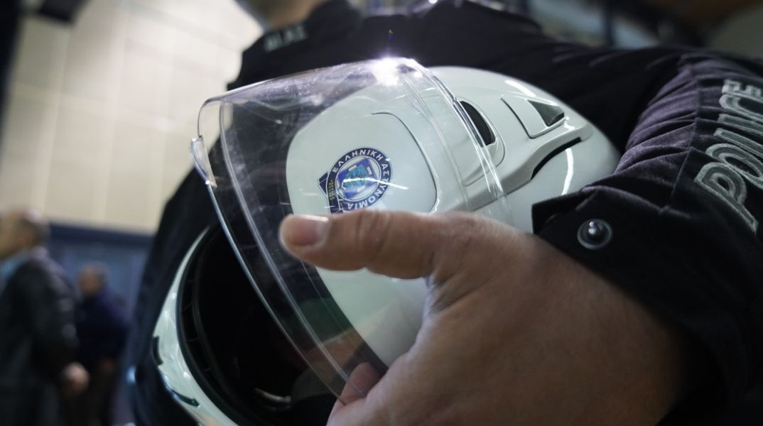 Αστυνομικός της ΕΛ.ΑΣ κρατάει το κράνος του