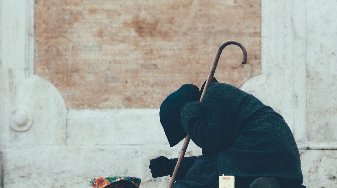 Γυναίκα επαιτεί σε δρόμο πόλης