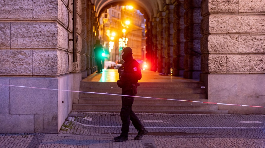 Αστυνομικός σε σημείο όπου έχει αποκλειστεί με κορδέλα της αστυνομίας στην Πράγα μετά το μακελειό στο Πανεπιστήμιο