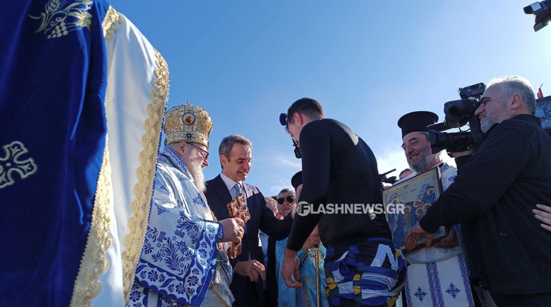 Ο Κυριάκος Μητσοτάκης δίνει σταυρουδάκι στον άνδρα που έπιασε τον Σταυρό από τη θάλασσα στα Χανιά