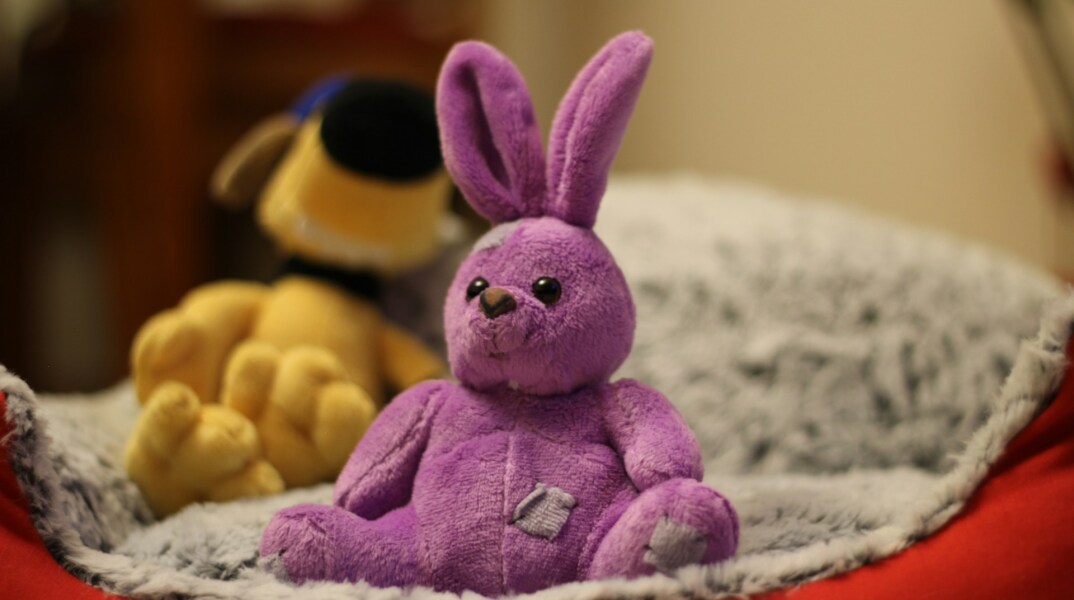 Λούτρινο κουκλάκι πάνω σε κρεβάτι