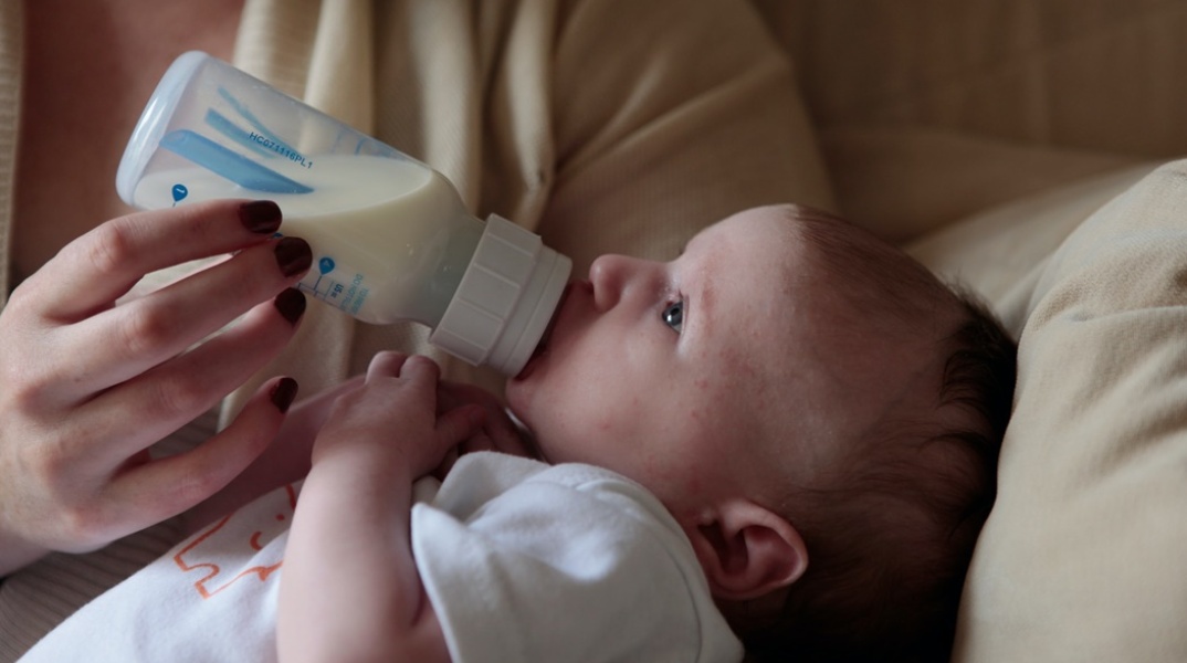 Μωράκι πίνει το γάλα του από μπιμπερό