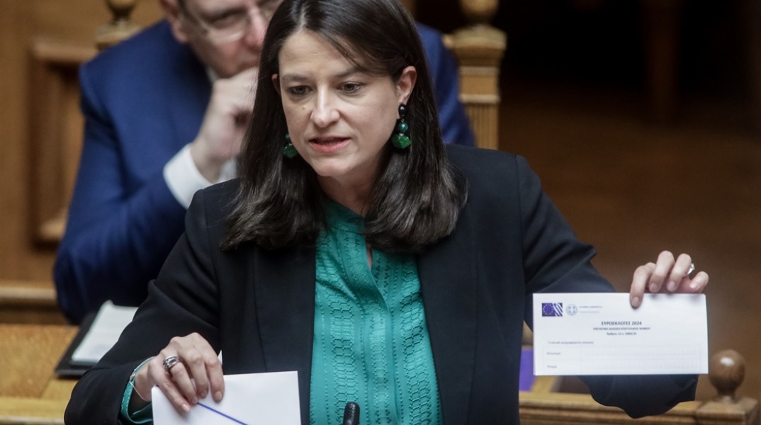 Η Νίκη Κεραμέως στη Βουλή κρατά στα χέρια της τους φακέλους για την επιστολική ψήφο