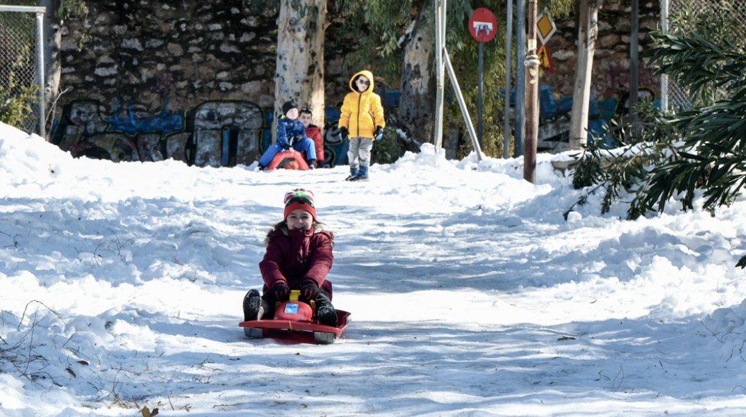 Παιδί παίζει στο χιονισμένο τοπίο