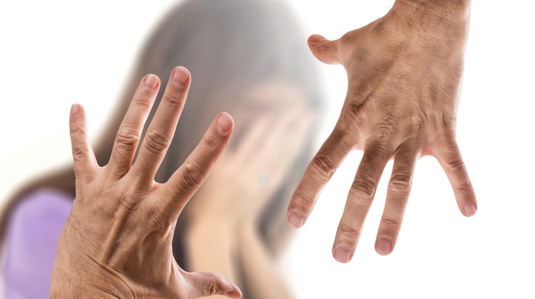 Χέρια που απειλούν γυναίκα η οποία προσπαθεί να προφυλαχθεί