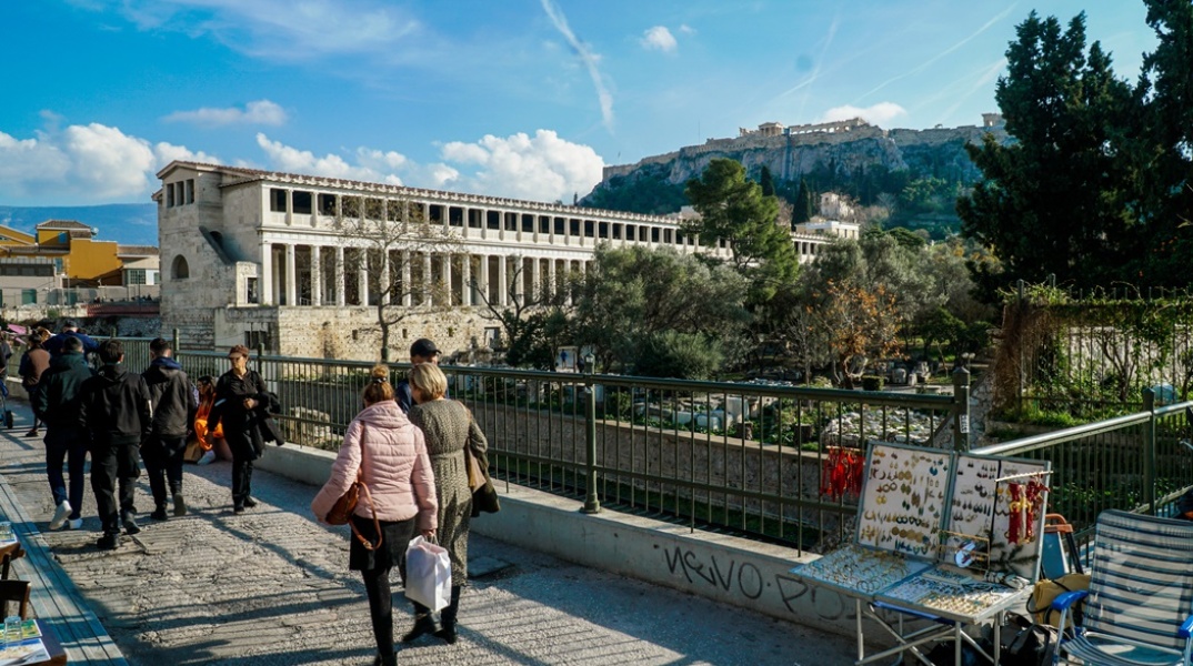 Ηλιοφάνεια και πολίτες που περπατούν στο Θησείο