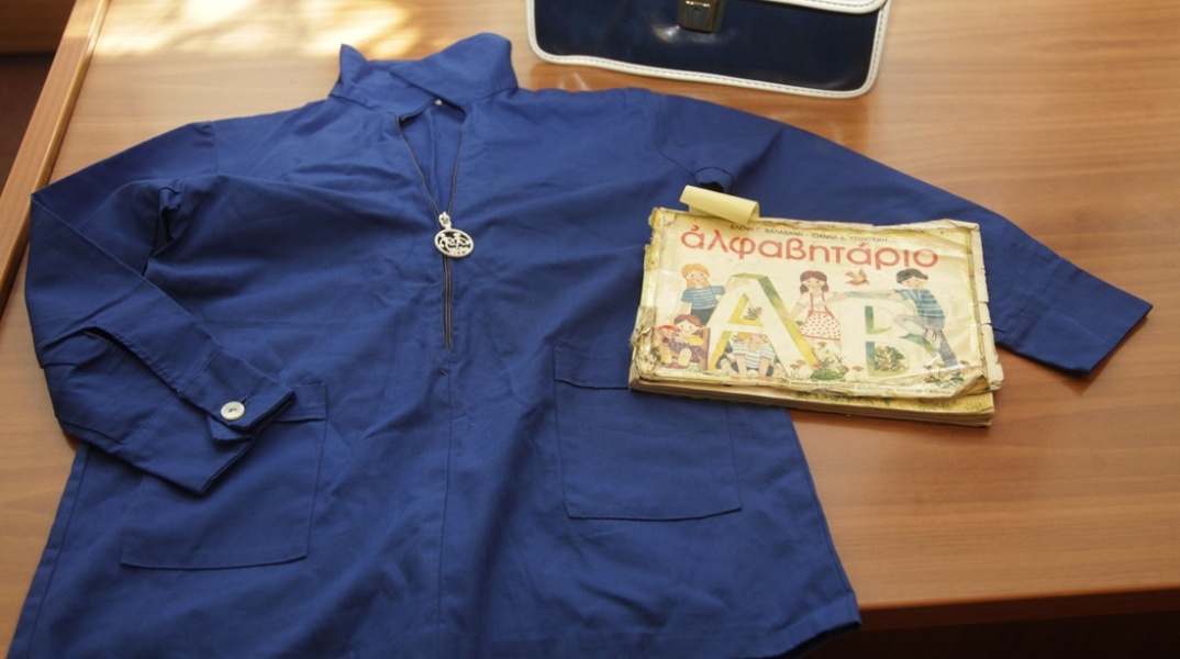 Μπλε ποδιά δίπλα με το αλφαβητάριο