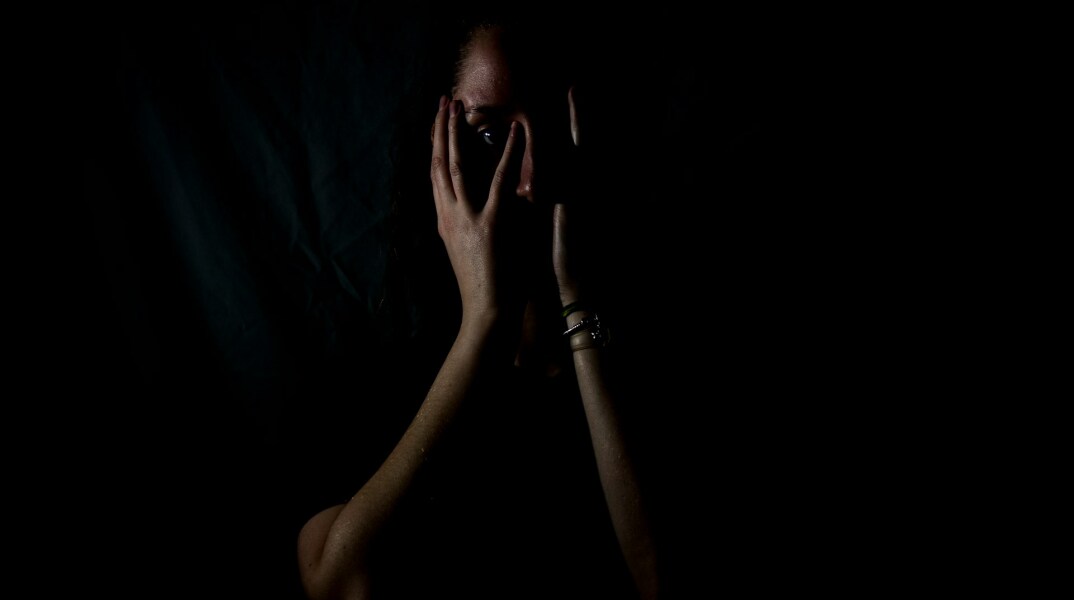 Γυναίκα που κρύβει το θλιμμένο πρόσωπό της με τα χέρια της