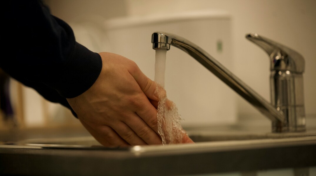 Άτομο που πλένει τα χέρια του κάτω από τη βρύση