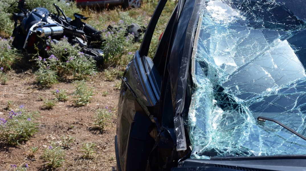 Μηχανή πεσμένη σε χωράφι και τα σημάδια στο παμπρίζ αυτοκινήτου μετά τη σύγκρουση σε αυτοκίνητο