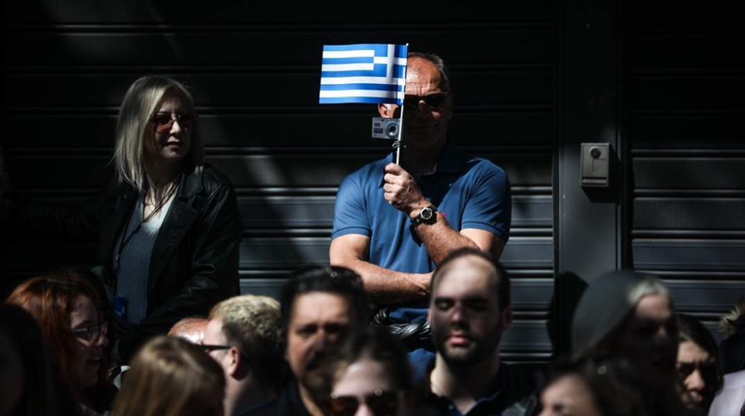 Πολίτες με σημαία στο χέρι σε δρόμο της Αθήνας