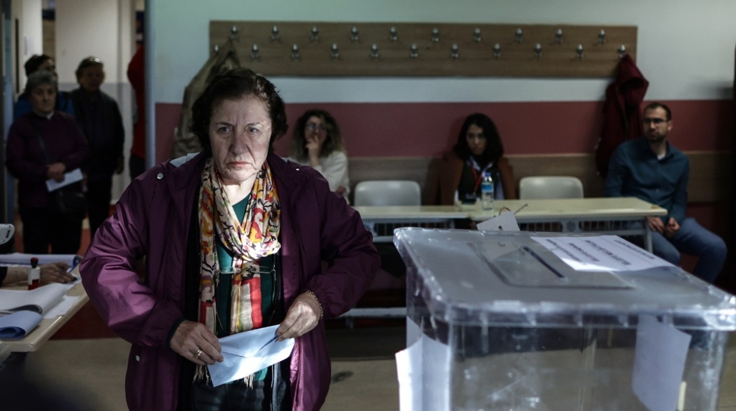 Γυναίκα με τον φάκελο με το ψηφοδέλτιο στο χέρι σε εκλογικό κέντρο της Τουρκίας