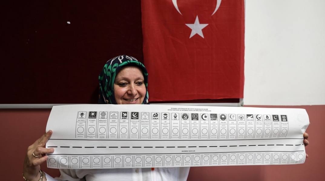 Γυναίκα κρατά ψηφοδέλτιο για τις Δημοτικές Εκλογές στην Τουρκία