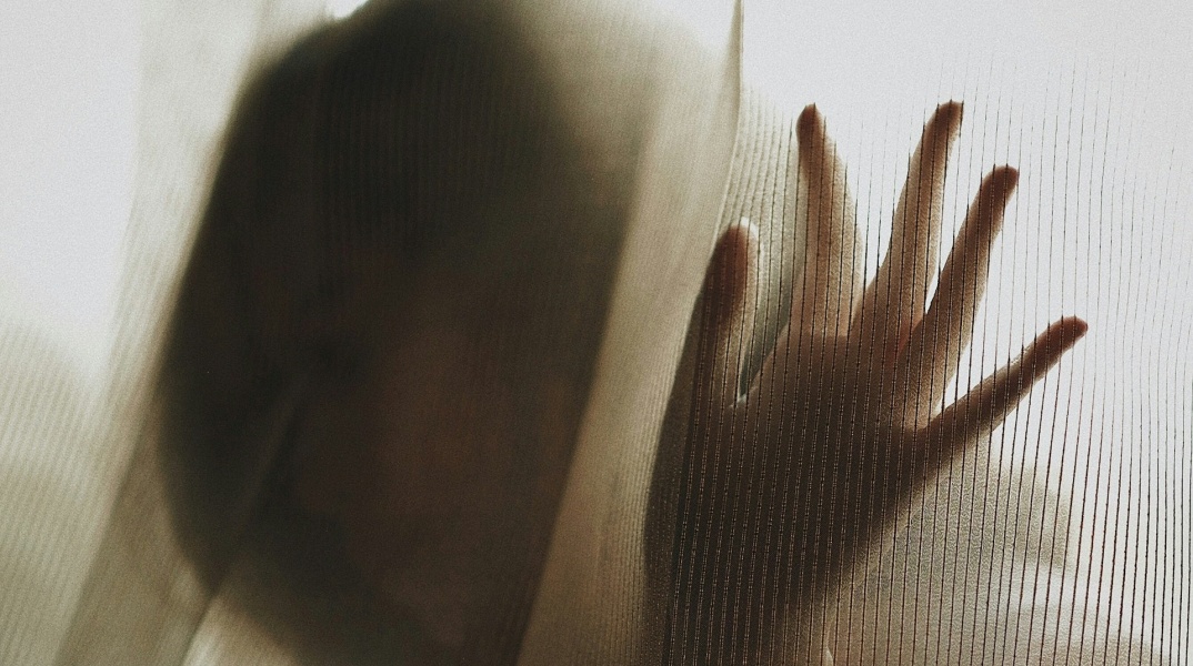 Γυναίκα πίσω από την κουρτίνα