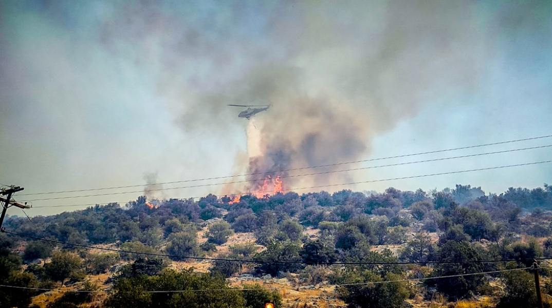 Πυροσβεστικό ελικόπτερο πετά πάνω από φωτιά στην Εύβοια
