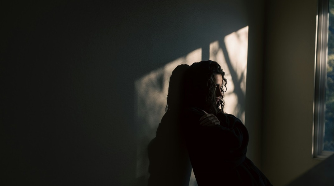 Άτομο στεναχωρημένο, καθισμένο στο πάτωμα σπιτιού 