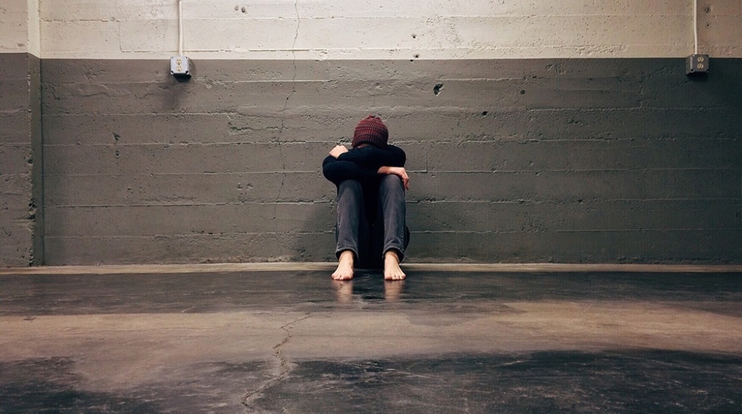 Αγόρι με τα χέρια που αγκαλιάζουν τα γόνατά του κρύβει το πρόσωπό του - Εικόνα που παραπέμπει σε Bullying και άσκηση βίας