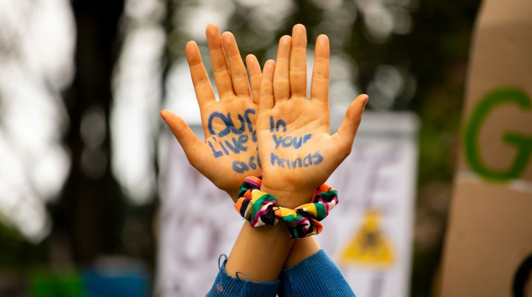 Η ζωή μας είναι στα χέρια σας, το σύνθημα που αναγράφεται στις παλάμες μιας διαδηλώτριας για το περιβάλλον