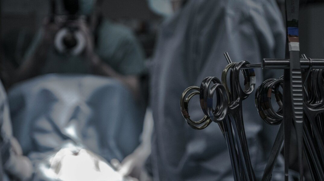 Ιατρικά εργαλεία στα δεξιά της οθόνης με φόνο χειρουργούς και χώρο χειρουργείου