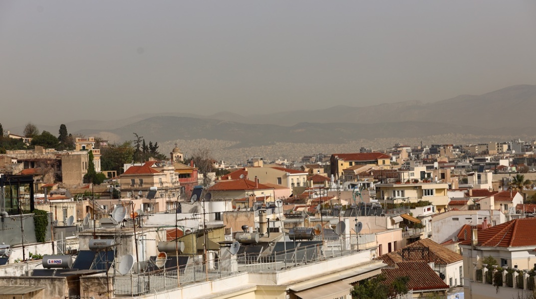 Η αφρικανική σκόνη δεν επιτρέπει να δούμε τον ορίζοντα πάνω από τις ταράτσες των κτιρίων στην Αττική