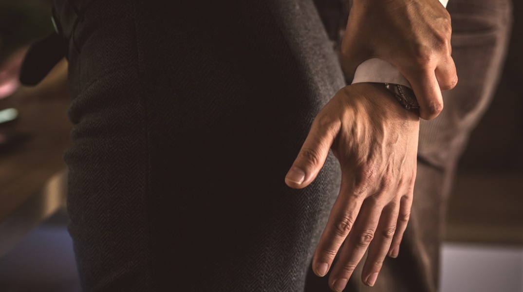 Χέρι άνδρα επιδιώκει να πιάσει τα οπίσθια γυναίκας, με το χέρι της να το απομακρύνει