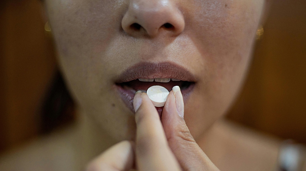 Γυναίκα παίρνει χάπι από στόματος για την ημικρανία