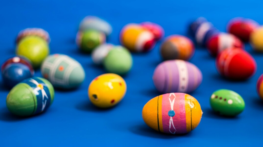 Αυγά βαμμένα σε μπλε επιφάνεια ενόψει Πάσχα