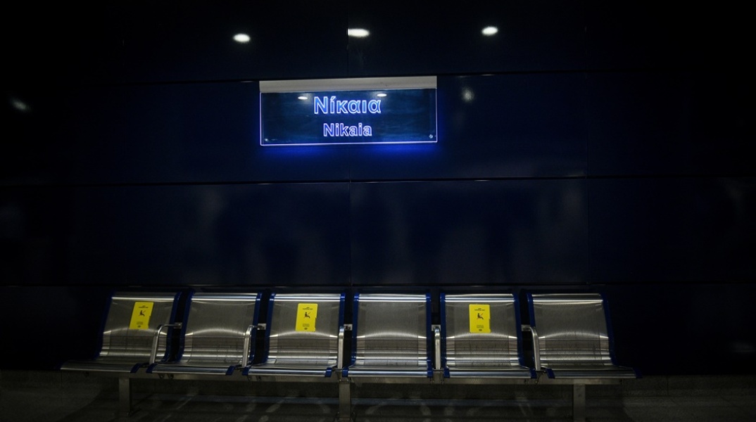 Εικόνα από τον σταθμό του μετρό «Νίκαια» - Η ταμπέλα του σταθμού πάνω από θέσεις για να κάτσουν επιβάτες