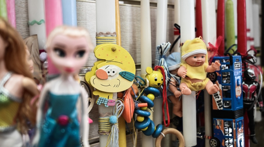 Λαμπάδες με διάφορα διακοσμητικά κρεμασμένες σε κατάστημα