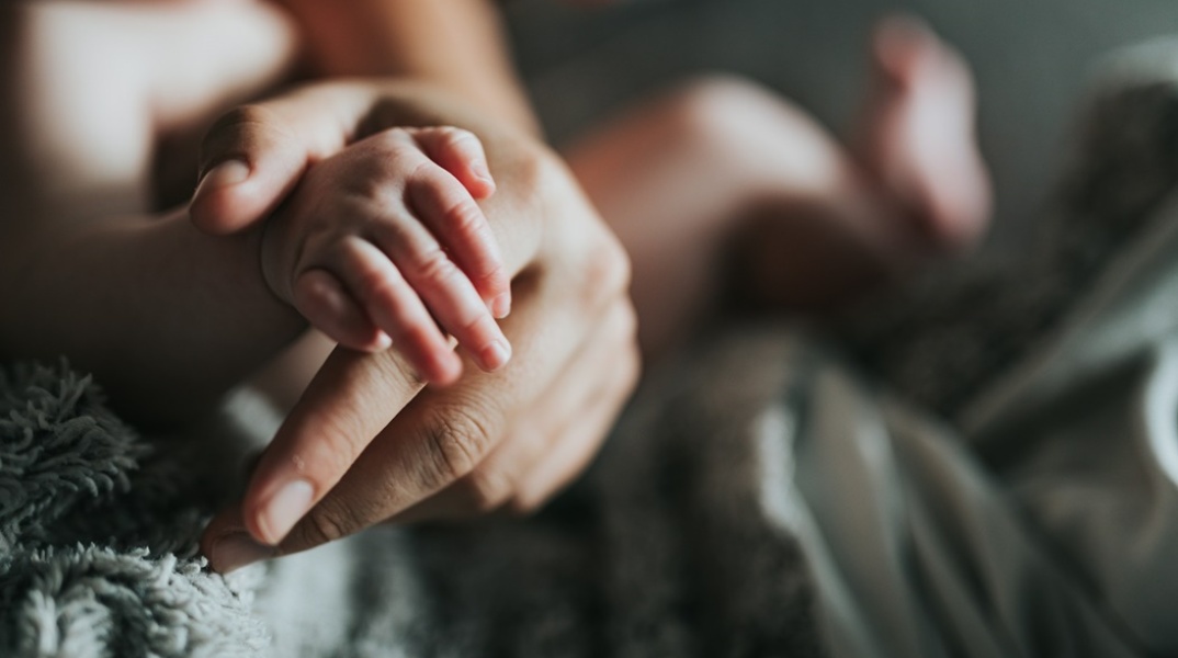 Χεράκι μωρού στο χέρι άλλου ατόμου