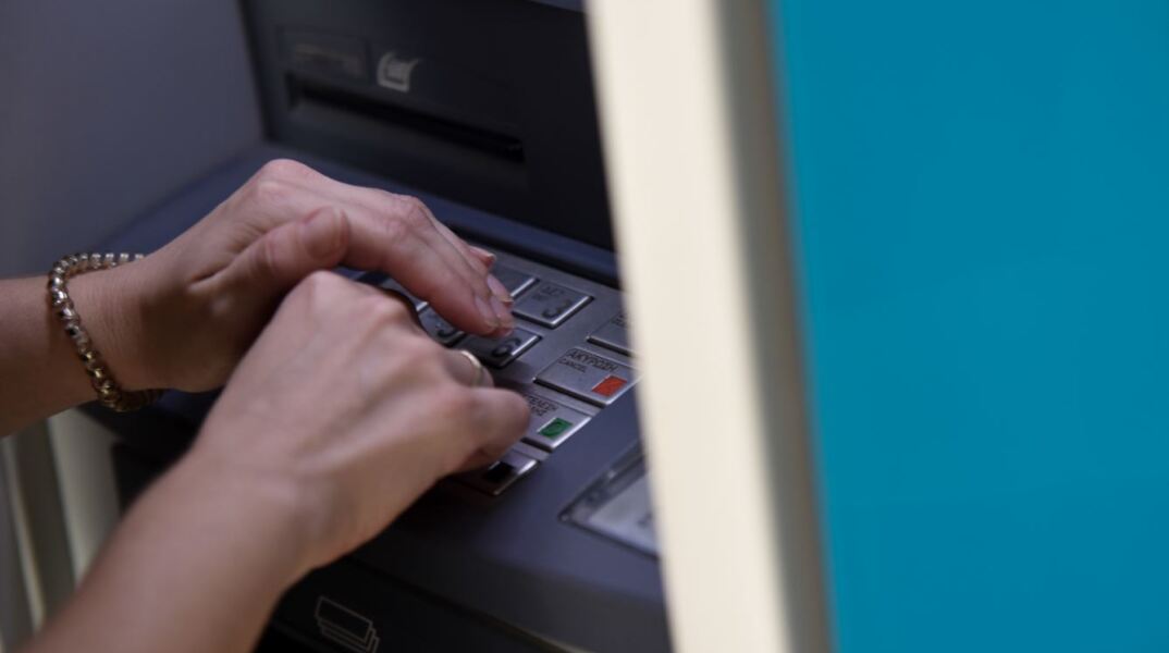 Γυναίκα πληκτρολογεί σε ΑΤΜ