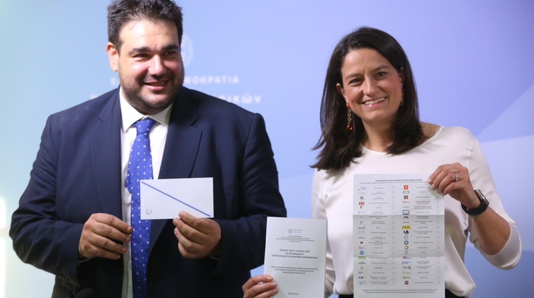 Η Νίκη Κεραμέως και ο Θοδωρής Λιβάνιος κρατούν τον φάκελο και το περιεχόμενό του για την επιστολική ψήφο