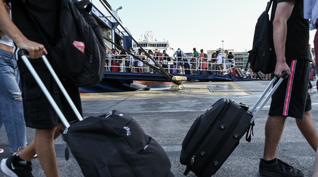 Πολίτες με βαλίτσες ετοιμάζονται για τον απόπλου από το λιμάνι του Πειραιά