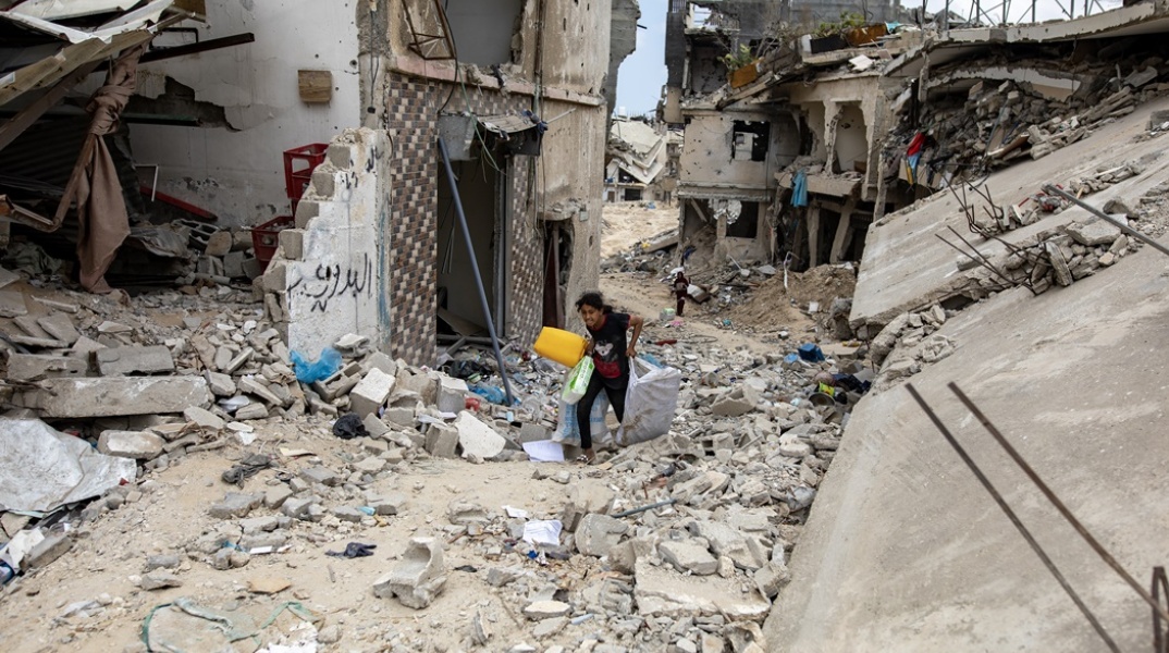 Κοριτσάκι περπατά σε ερείπια στη Γάζα