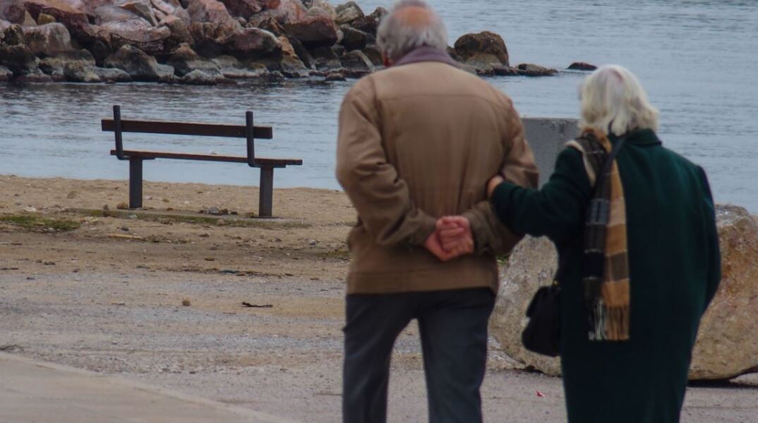 Συνταξιούχοι περπατούν κοντά στην ακρογιαλιά