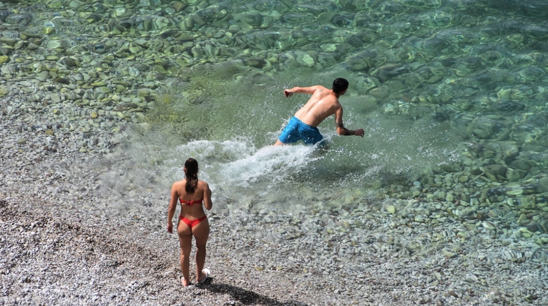 Άτομα σε παραλία ετοιμάζονται για βουτιά στη θάλασσα
